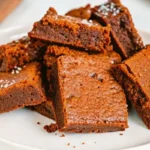 Thick and chewy 2 ingredient fudgy brownies stacked on a white plate